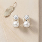 Pearl clip on studs with diamond-like stones on a beige surface | Ikecho Australia